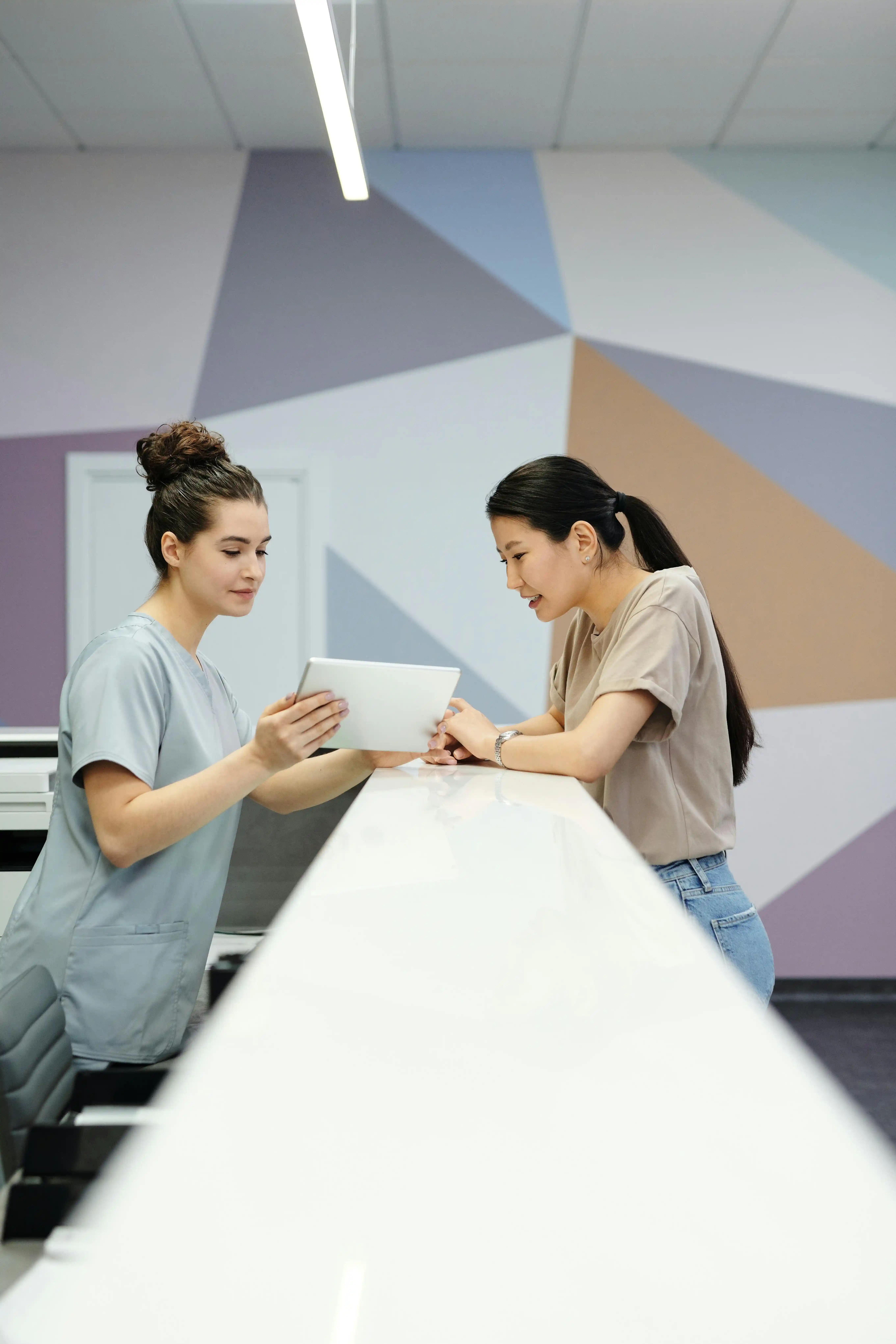 Receptionist showing tablet to woman